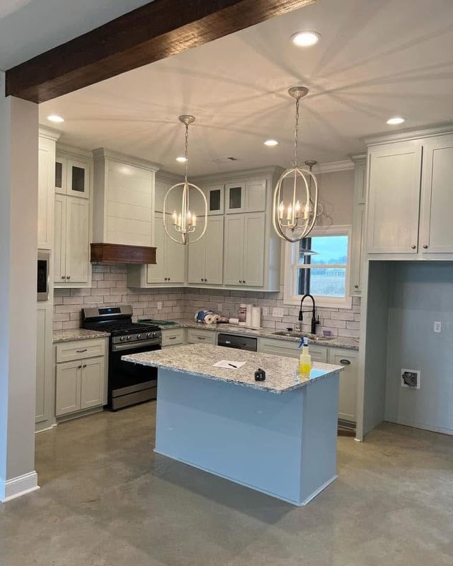 Kitchen with a stained concrete floor and a blue island