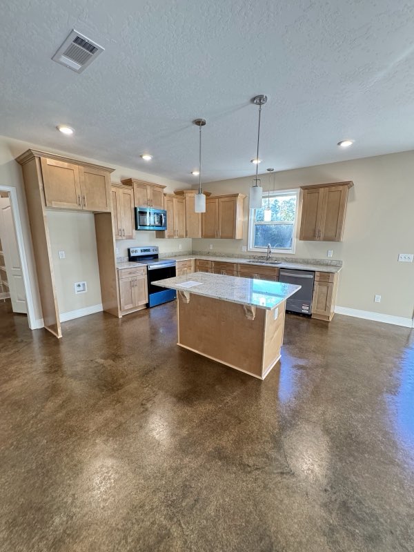 Open-plan kitchen and living area with a rich brown stained concrete floor